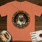 Let Go and Let Dog Pug T-Shirt flat lay in Melon, featuring a baroque medallion engraving of a haloed Pug with paws raised, framed in gold scrollwork.