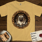 Let Go and Let Dog Pug T-Shirt flat lay in Mustard, featuring a baroque medallion engraving of a haloed Pug with paws raised, framed in gold scrollwork.