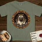 Let Go and Let Dog Pug T-Shirt flat lay in Sage, featuring a baroque medallion engraving of a haloed Pug with paws raised, framed in gold scrollwork.