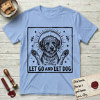 Let Go and Let Dog Rescue Mutt T-Shirt flat lay in Light Blue, featuring a bold black-and-white woodcut of a haloed scruffy rescue mutt with both front paws raised.