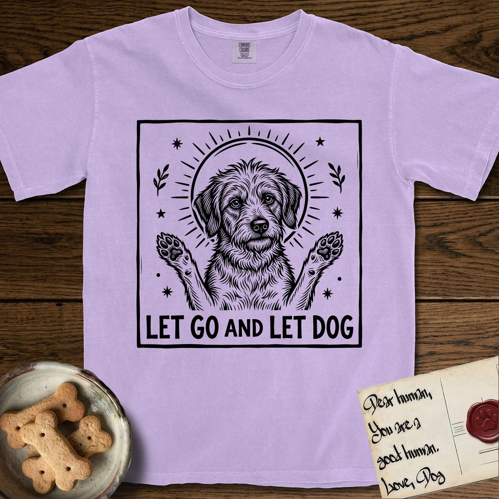 Let Go and Let Dog Rescue Mutt T-Shirt flat lay in Orchid, featuring a bold black-and-white woodcut of a haloed scruffy rescue mutt with both front paws raised.