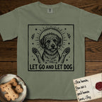 Let Go and Let Dog Rescue Mutt T-Shirt flat lay in Sage, featuring a bold black-and-white woodcut of a haloed scruffy rescue mutt with both front paws raised.