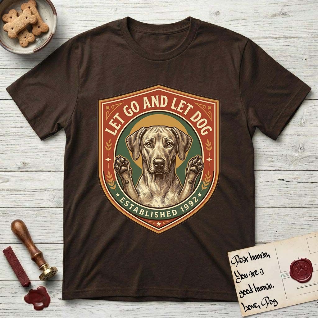 Let Go and Let Dog Rhodesian Ridgeback T-Shirt flat lay in Dark Chocolate, featuring a vintage engraved crest of a haloed Rhodesian Ridgeback with front paws raised.
