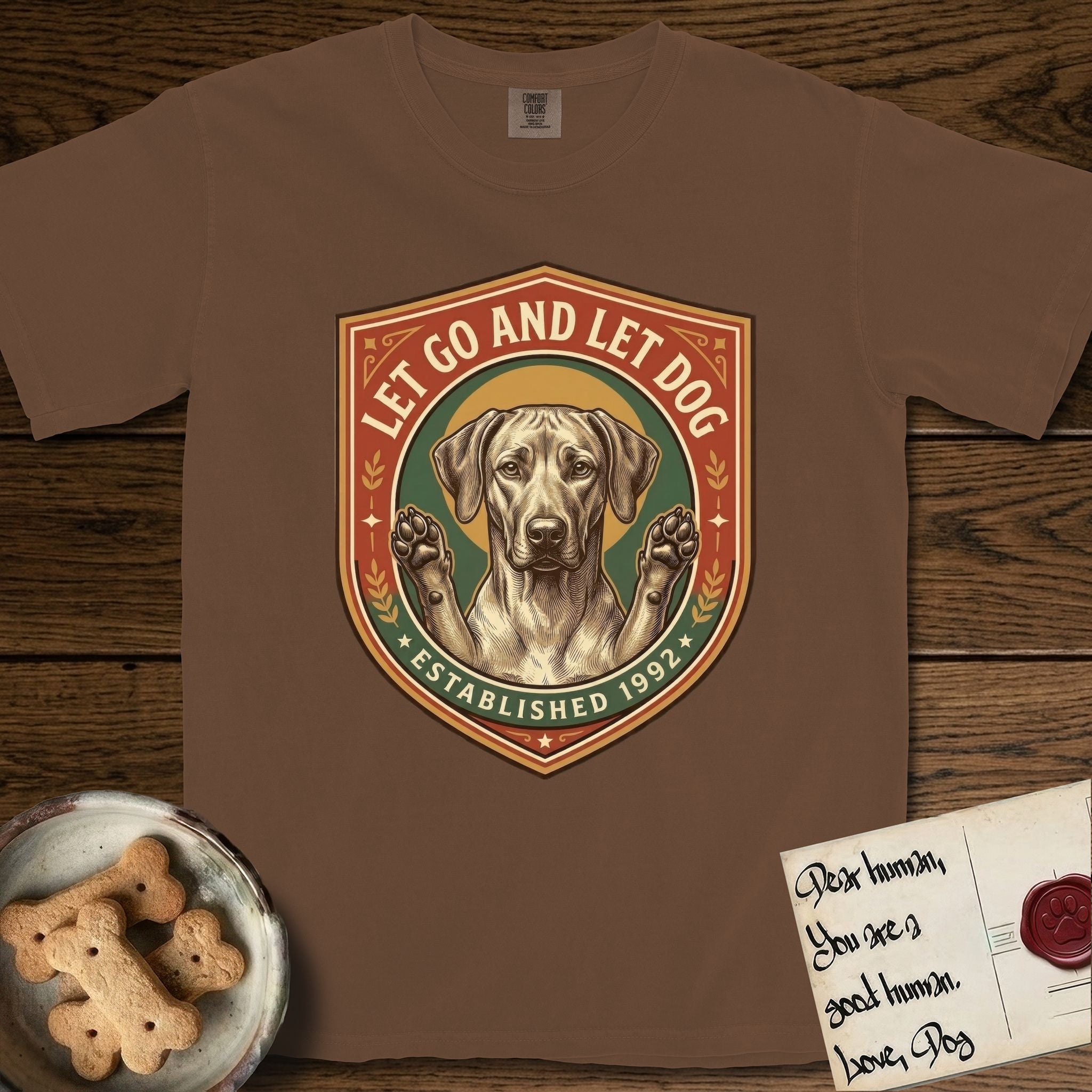 Let Go and Let Dog Rhodesian Ridgeback T-Shirt flat lay in Espresso, featuring a vintage engraved crest of a haloed Rhodesian Ridgeback with front paws raised.