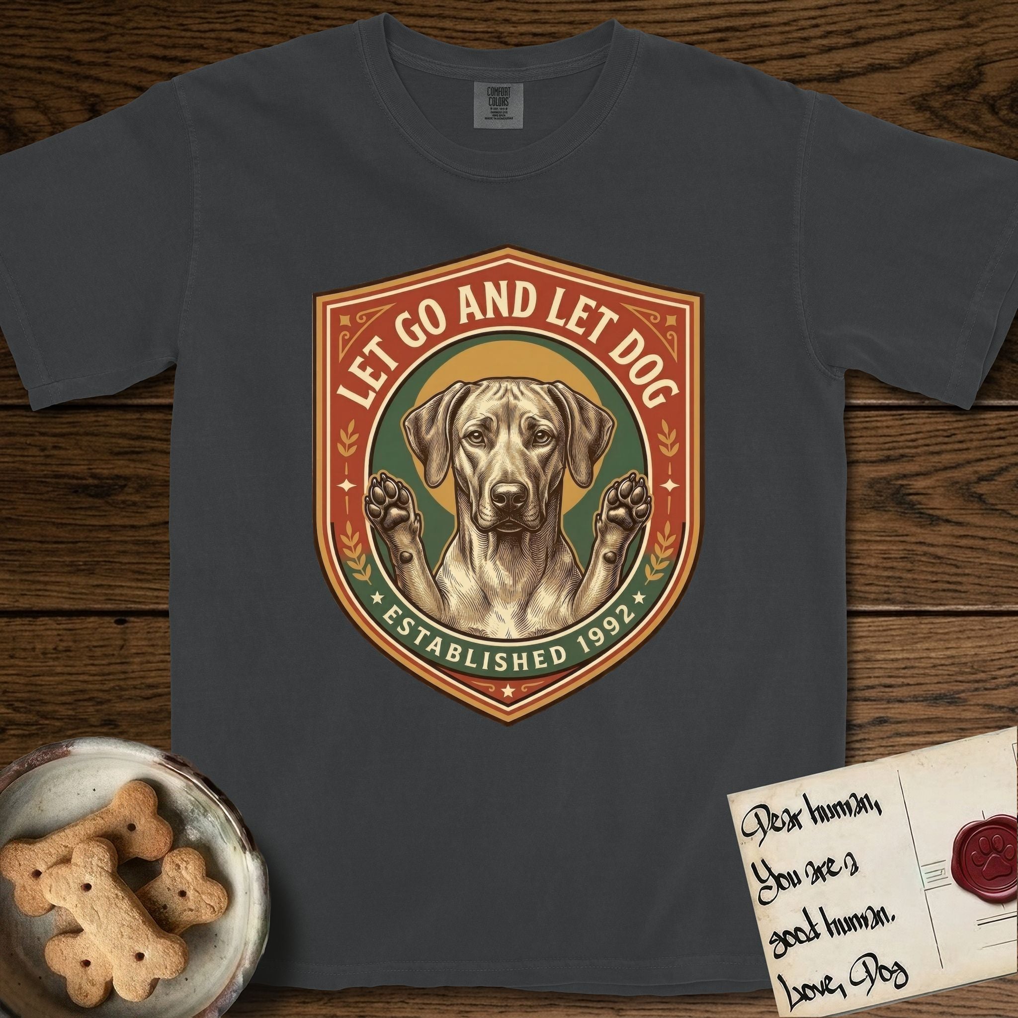 Let Go and Let Dog Rhodesian Ridgeback T-Shirt flat lay in Graphite, featuring a vintage engraved crest of a haloed Rhodesian Ridgeback with front paws raised.
