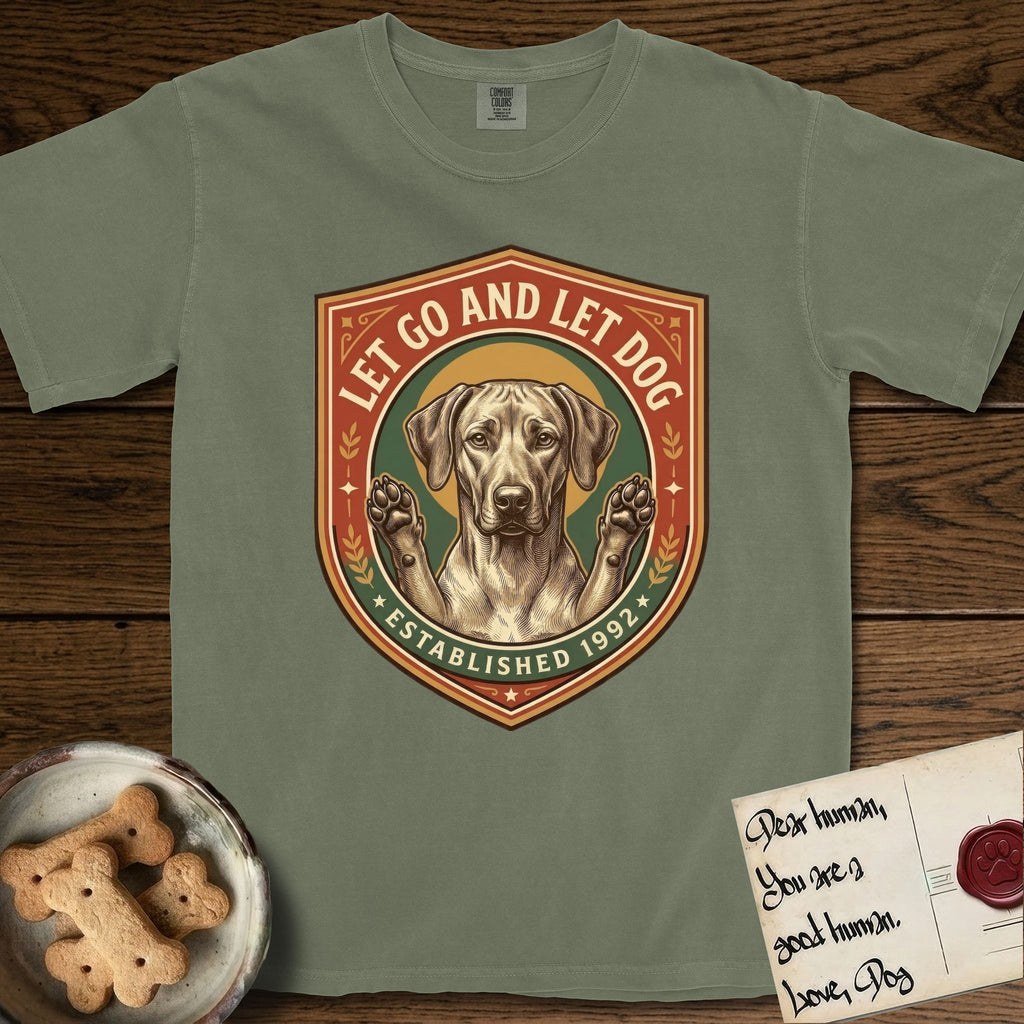 Let Go and Let Dog Rhodesian Ridgeback T-Shirt flat lay in Sage, featuring a vintage engraved crest of a haloed Rhodesian Ridgeback with front paws raised.