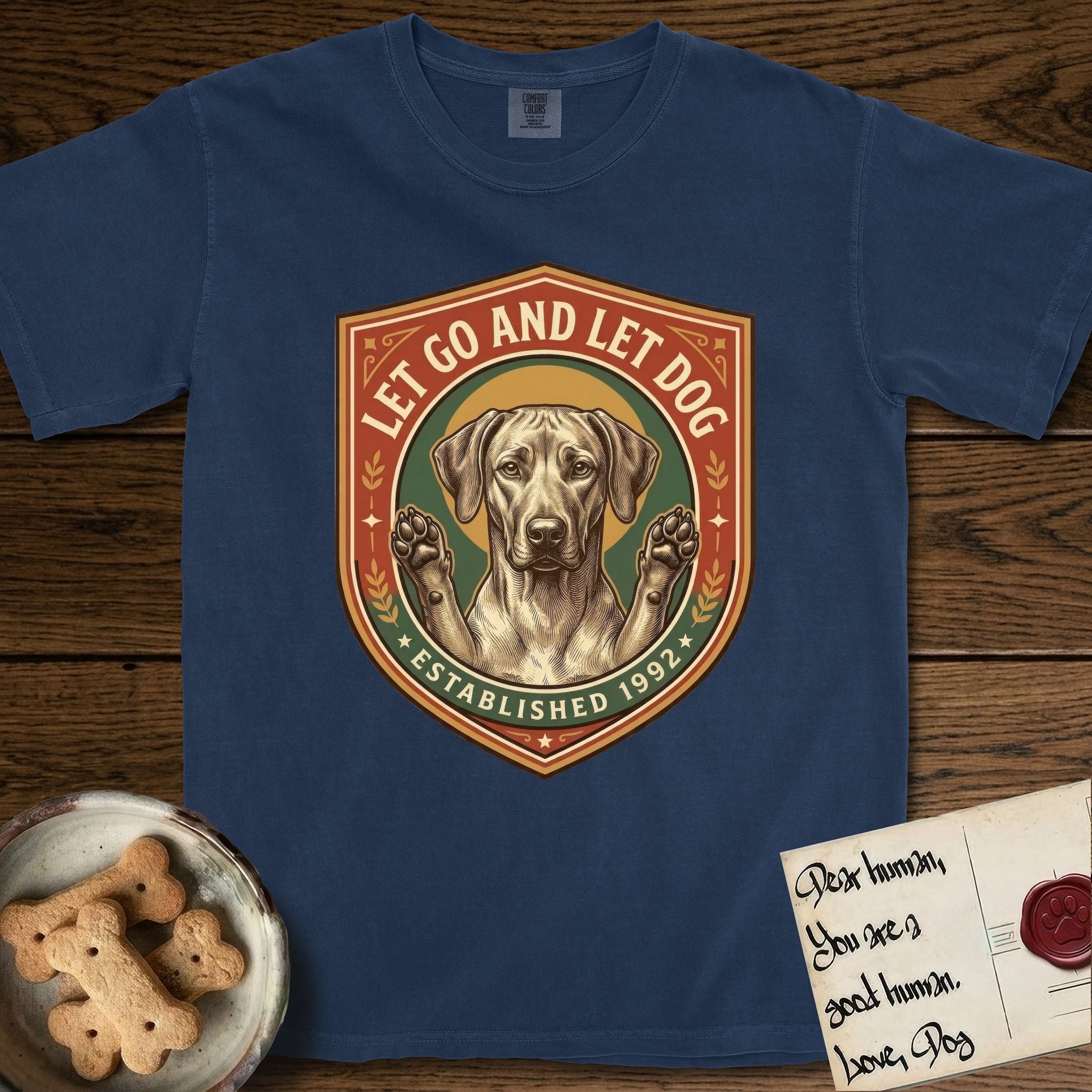 Let Go and Let Dog Rhodesian Ridgeback T-Shirt flat lay in True Navy, featuring a vintage engraved crest of a haloed Rhodesian Ridgeback with front paws raised.