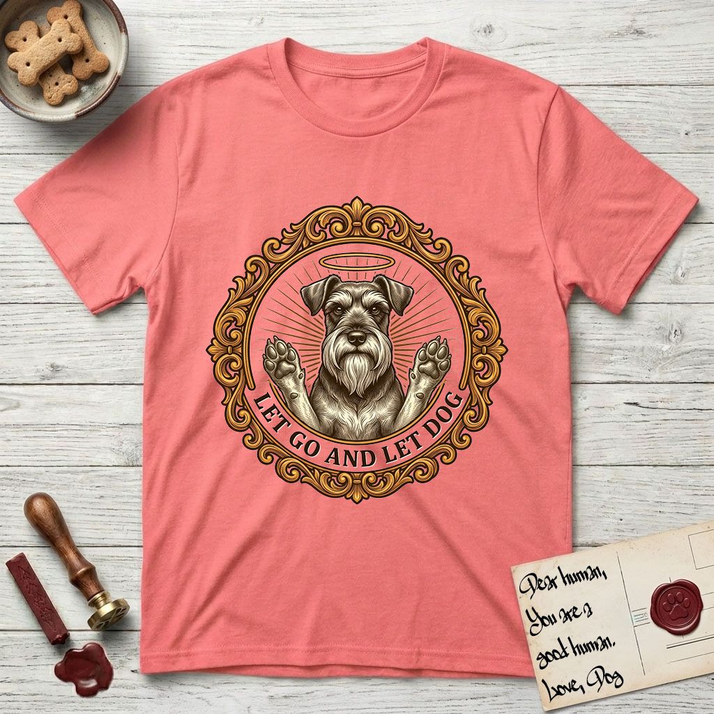 Let Go and Let Dog Schnauzer T-Shirt flat lay in Coral Silk, featuring an ornate gilded medallion of a haloed Schnauzer with front paws raised.