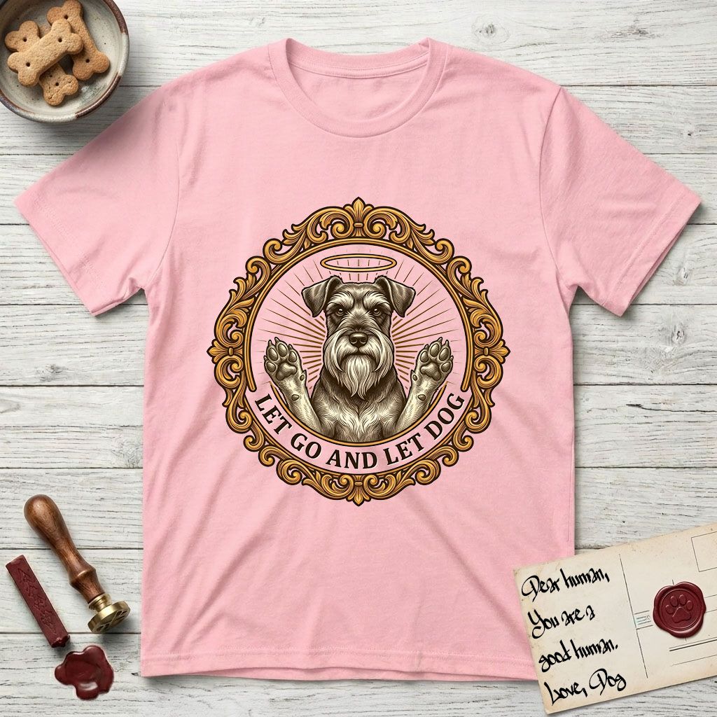 Let Go and Let Dog Schnauzer T-Shirt flat lay in Light Pink, featuring an ornate gilded medallion of a haloed Schnauzer with front paws raised.
