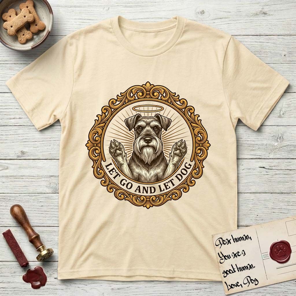 Let Go and Let Dog Schnauzer T-Shirt flat lay in Natural, featuring an ornate gilded medallion of a haloed Schnauzer with front paws raised.