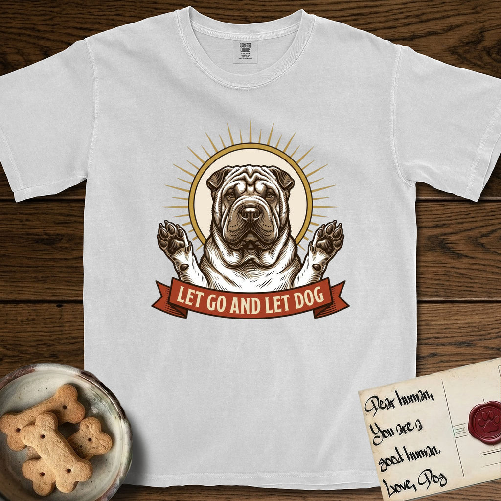 Let Go and Let Dog Shar-Pei T-Shirt flat lay in White, featuring an engraved woodcut portrait of a haloed wrinkled Shar-Pei, paws raised, sunburst rays behind her and a ribbon banner below.