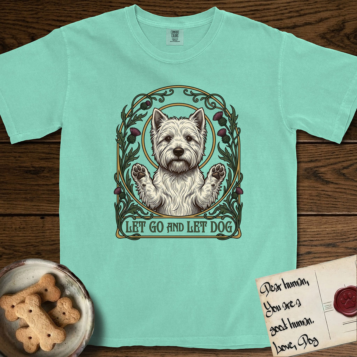 Let Go and Let Dog Westie T-Shirt flat lay in Island Reef, featuring an Art Nouveau arch of thistles and curling vines around a haloed West Highland White Terrier, paws raised.
