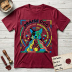 Praise Dog From Whom All Blessings Flow Australian Cattle Dog T-Shirt flat lay in Antique Cherry Red, featuring a neon pop-art illustration of an abstract Australian Cattle Dog with bold outlined "Praise Dog From Whom All Blessings Flow" lettering.
