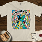Praise Dog From Whom All Blessings Flow Australian Cattle Dog T-Shirt flat lay in Ivory, featuring a neon pop-art illustration of an abstract Australian Cattle Dog with bold outlined "Praise Dog From Whom All Blessings Flow" lettering.