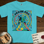 Praise Dog From Whom All Blessings Flow Australian Cattle Dog T-Shirt flat lay in Lagoon Blue, featuring a neon pop-art illustration of an abstract Australian Cattle Dog with bold outlined "Praise Dog From Whom All Blessings Flow" lettering.