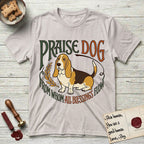 Praise Dog From Whom All Blessings Flow Basset Hound T-Shirt flat lay in Ice Grey, featuring an art nouveau hand-lettered design with a sad-eyed Basset Hound sitting beside a golden laurel sprig and the words Praise Dog From Whom All Blessings Flow.