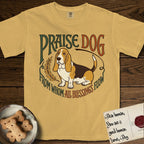 Praise Dog From Whom All Blessings Flow Basset Hound T-Shirt flat lay in Mustard, featuring an art nouveau hand-lettered design with a sad-eyed Basset Hound sitting beside a golden laurel sprig and the words Praise Dog From Whom All Blessings Flow.