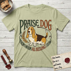 Praise Dog From Whom All Blessings Flow Basset Hound T-Shirt flat lay in Pistachio, featuring an art nouveau hand-lettered design with a sad-eyed Basset Hound sitting beside a golden laurel sprig and the words Praise Dog From Whom All Blessings Flow.