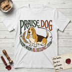 Praise Dog From Whom All Blessings Flow Basset Hound T-Shirt flat lay in White, featuring an art nouveau hand-lettered design with a sad-eyed Basset Hound sitting beside a golden laurel sprig and the words Praise Dog From Whom All Blessings Flow.