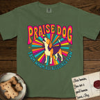 Praise Dog From Whom All Blessings Flow Beagle T-Shirt flat lay in Moss, featuring a groovy psychedelic sunburst design with a Beagle howling skyward at the center and the words Praise Dog From Whom All Blessings Flow in rainbow bubble letters.