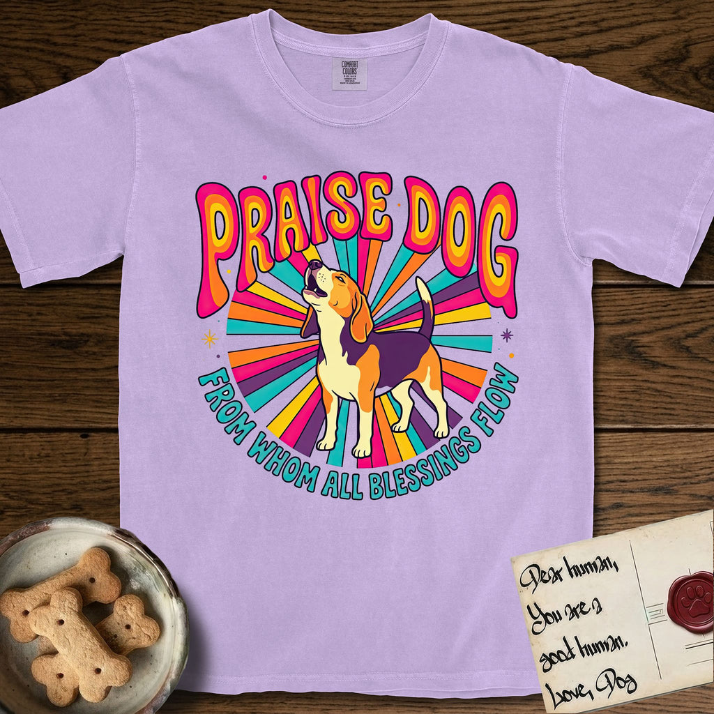 Praise Dog From Whom All Blessings Flow Beagle T-Shirt flat lay in Orchid, featuring a groovy psychedelic sunburst design with a Beagle howling skyward at the center and the words Praise Dog From Whom All Blessings Flow in rainbow bubble letters.