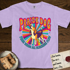 Praise Dog From Whom All Blessings Flow Beagle T-Shirt flat lay in Orchid, featuring a groovy psychedelic sunburst design with a Beagle howling skyward at the center and the words Praise Dog From Whom All Blessings Flow in rainbow bubble letters.