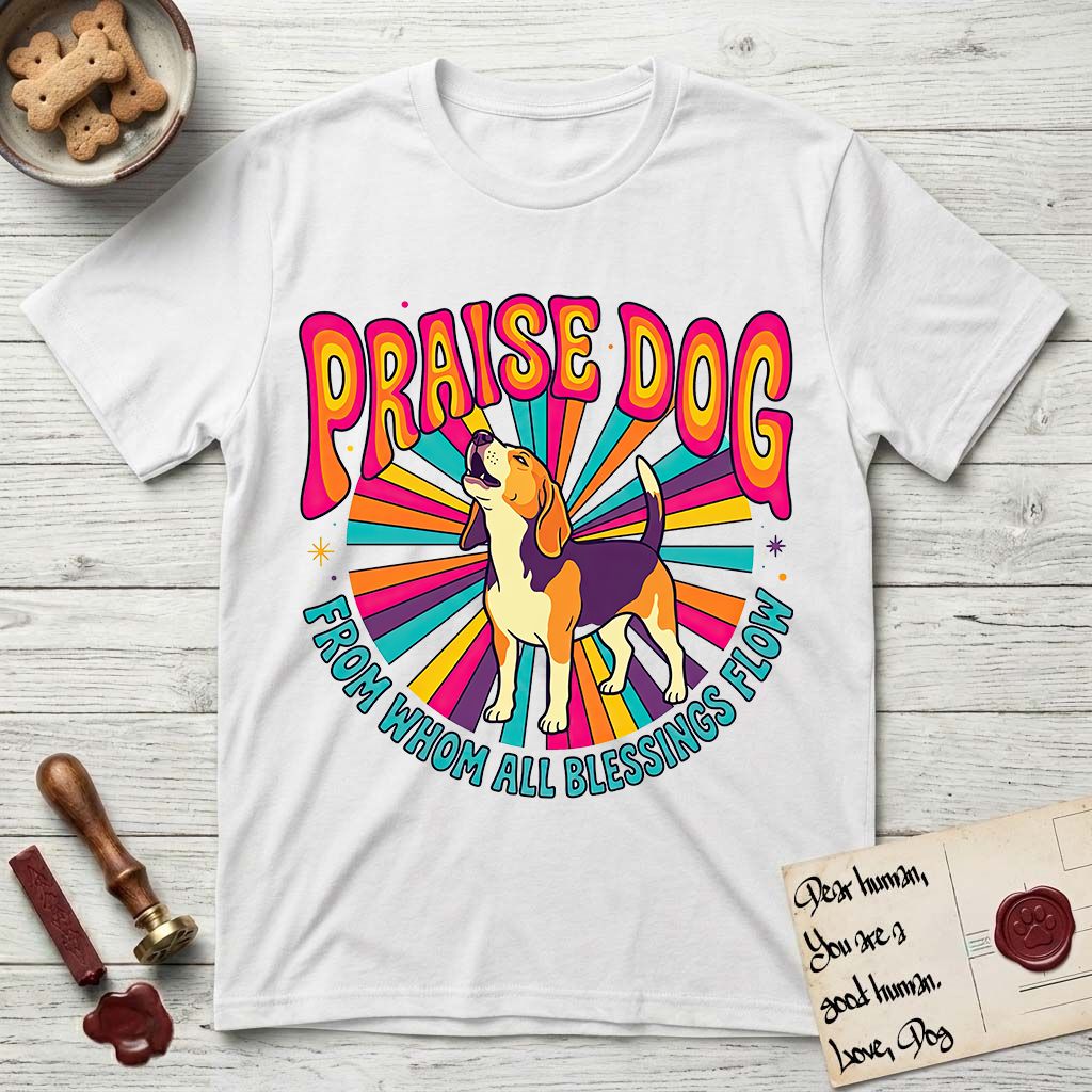 Praise Dog From Whom All Blessings Flow Beagle T-Shirt flat lay in White, featuring a groovy psychedelic sunburst design with a Beagle howling skyward at the center and the words Praise Dog From Whom All Blessings Flow in rainbow bubble letters.
