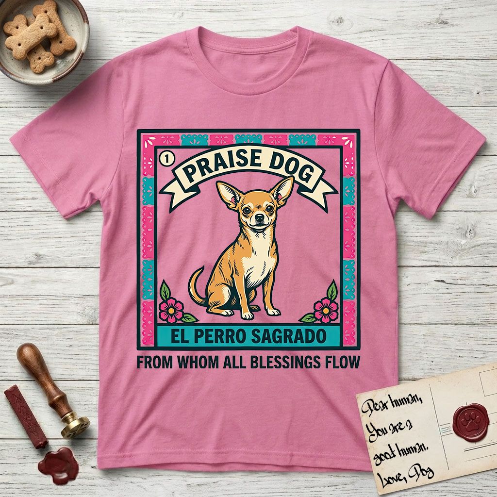 Praise Dog From Whom All Blessings Flow Chihuahua T-Shirt flat lay in Azalea, featuring a loteria-style folk art card with a Chihuahua seated inside a papel picado border, a banner reading El Perro Sagrado, and the words Praise Dog From Whom All Blessings Flow.