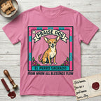Praise Dog From Whom All Blessings Flow Chihuahua T-Shirt flat lay in Azalea, featuring a loteria-style folk art card with a Chihuahua seated inside a papel picado border, a banner reading El Perro Sagrado, and the words Praise Dog From Whom All Blessings Flow.