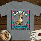 Praise Dog From Whom All Blessings Flow Chihuahua T-Shirt flat lay in Granite, featuring a loteria-style folk art card with a Chihuahua seated inside a papel picado border, a banner reading El Perro Sagrado, and the words Praise Dog From Whom All Blessings Flow.