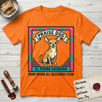 Praise Dog From Whom All Blessings Flow Chihuahua T-Shirt flat lay in Orange, featuring a loteria-style folk art card with a Chihuahua seated inside a papel picado border, a banner reading El Perro Sagrado, and the words Praise Dog From Whom All Blessings Flow.