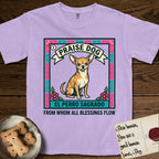 Praise Dog From Whom All Blessings Flow Chihuahua T-Shirt flat lay in Orchid, featuring a loteria-style folk art card with a Chihuahua seated inside a papel picado border, a banner reading El Perro Sagrado, and the words Praise Dog From Whom All Blessings Flow.
