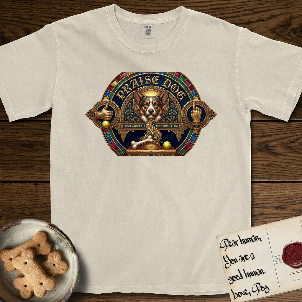 Praise Dog From Whom All Blessings Flow Corgi T-Shirt flat lay in Ivory, featuring a jeweled baroque throne emblem with a Corgi at center, a golden gemstone frame, raised golden hands in blessing, and the words Praise Dog.