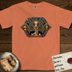 Praise Dog From Whom All Blessings Flow Corgi T-Shirt flat lay in Melon, featuring a jeweled baroque throne emblem with a Corgi at center, a golden gemstone frame, raised golden hands in blessing, and the words Praise Dog.