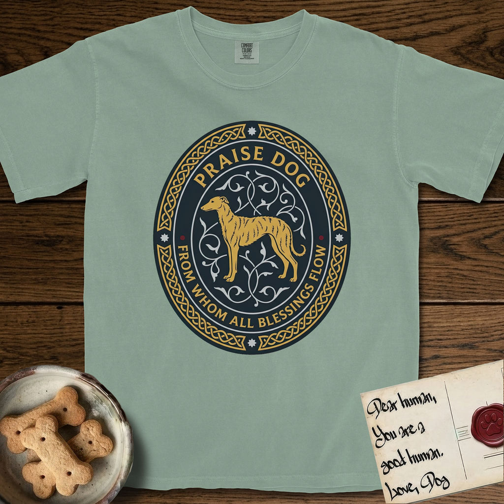 Praise Dog From Whom All Blessings Flow Galgo T-Shirt flat lay in Bay, featuring a gold and navy oval medallion with a brindle Galgo standing in profile over silver filigree vines, a knotwork border, and the words Praise Dog From Whom All Blessings Flow.