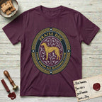 Praise Dog From Whom All Blessings Flow Galgo T-Shirt flat lay in Maroon, featuring a gold and navy oval medallion with a brindle Galgo standing in profile over silver filigree vines, a knotwork border, and the words Praise Dog From Whom All Blessings Flow.