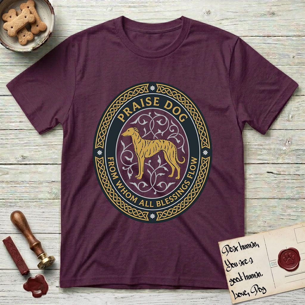 Praise Dog From Whom All Blessings Flow Galgo T-Shirt flat lay in Maroon, featuring a gold and navy oval medallion with a brindle Galgo standing in profile over silver filigree vines, a knotwork border, and the words Praise Dog From Whom All Blessings Flow.