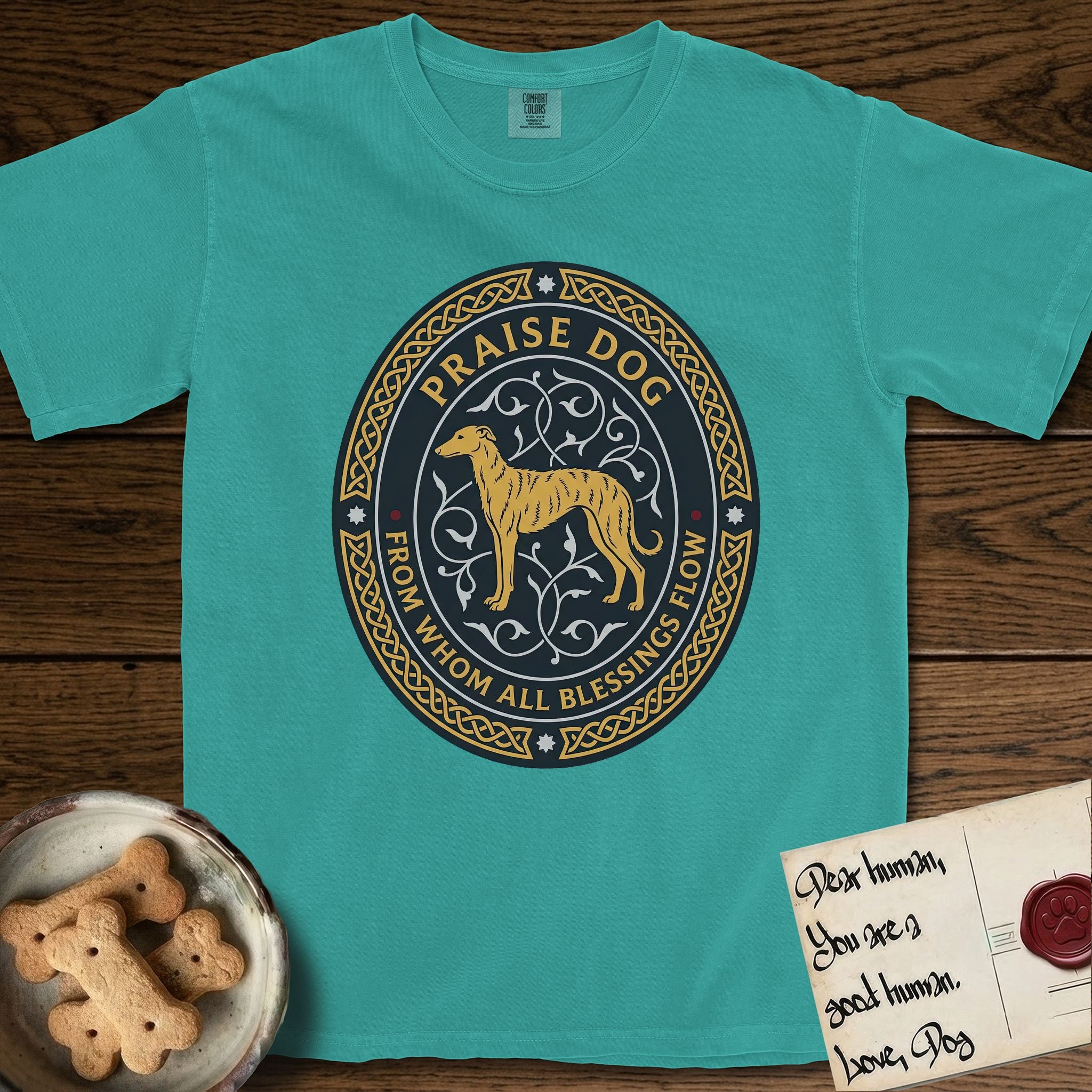 Praise Dog From Whom All Blessings Flow Galgo T-Shirt flat lay in Seafoam, featuring a gold and navy oval medallion with a brindle Galgo standing in profile over silver filigree vines, a knotwork border, and the words Praise Dog From Whom All Blessings Flow.