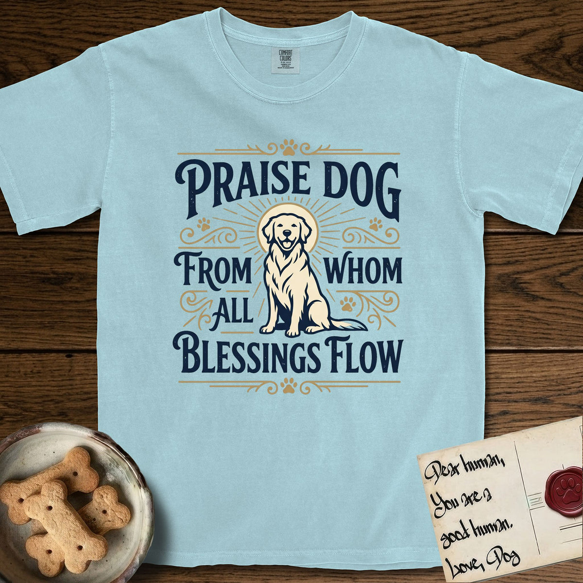 Praise Dog From Whom All Blessings Flow Golden Retriever T-Shirt flat lay in Chambray, featuring a bold Western hand-lettered "Praise Dog" design in navy and gold with a haloed Golden Retriever at center.