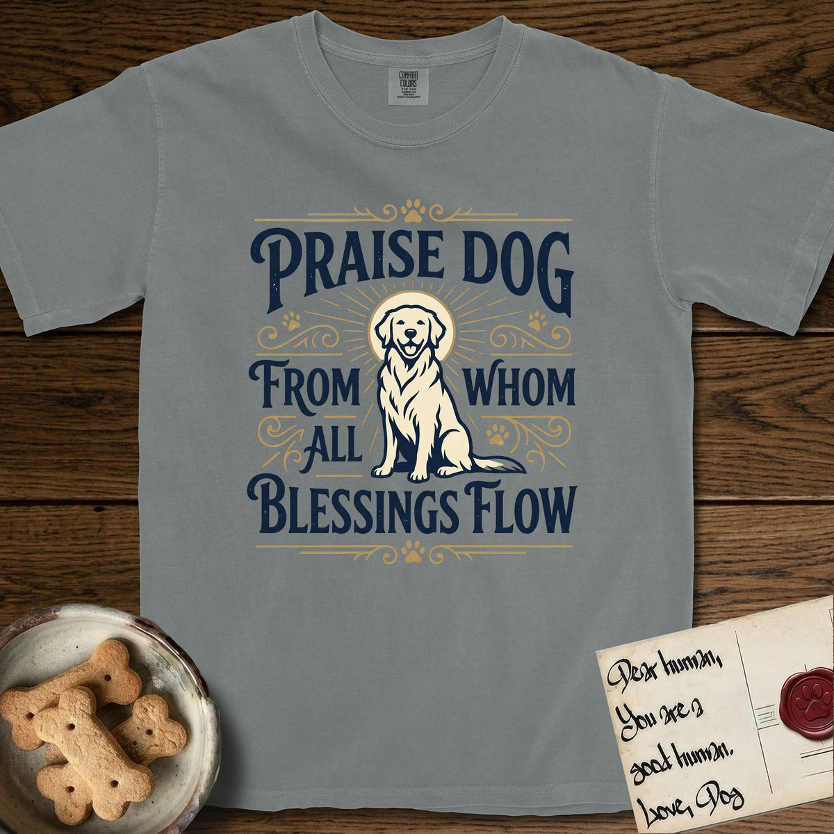 Praise Dog From Whom All Blessings Flow Golden Retriever T-Shirt flat lay in Granite, featuring a bold Western hand-lettered "Praise Dog" design in navy and gold with a haloed Golden Retriever at center.