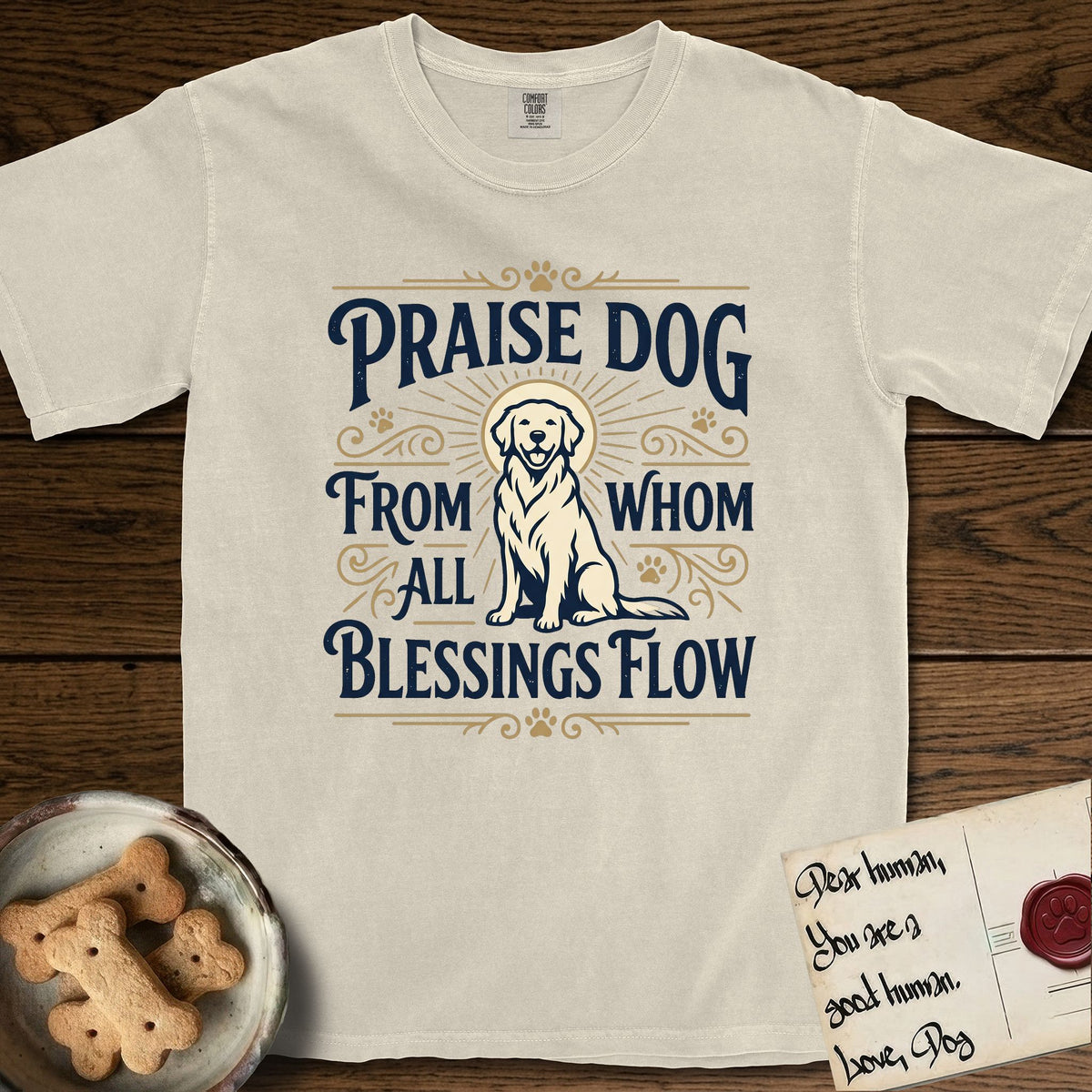 Praise Dog From Whom All Blessings Flow Golden Retriever T-Shirt flat lay in Ivory, featuring a bold Western hand-lettered "Praise Dog" design in navy and gold with a haloed Golden Retriever at center.