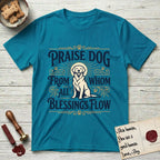 Praise Dog From Whom All Blessings Flow Golden Retriever T-Shirt flat lay in Tropical Blue, featuring a bold Western hand-lettered "Praise Dog" design in navy and gold with a haloed Golden Retriever at center.
