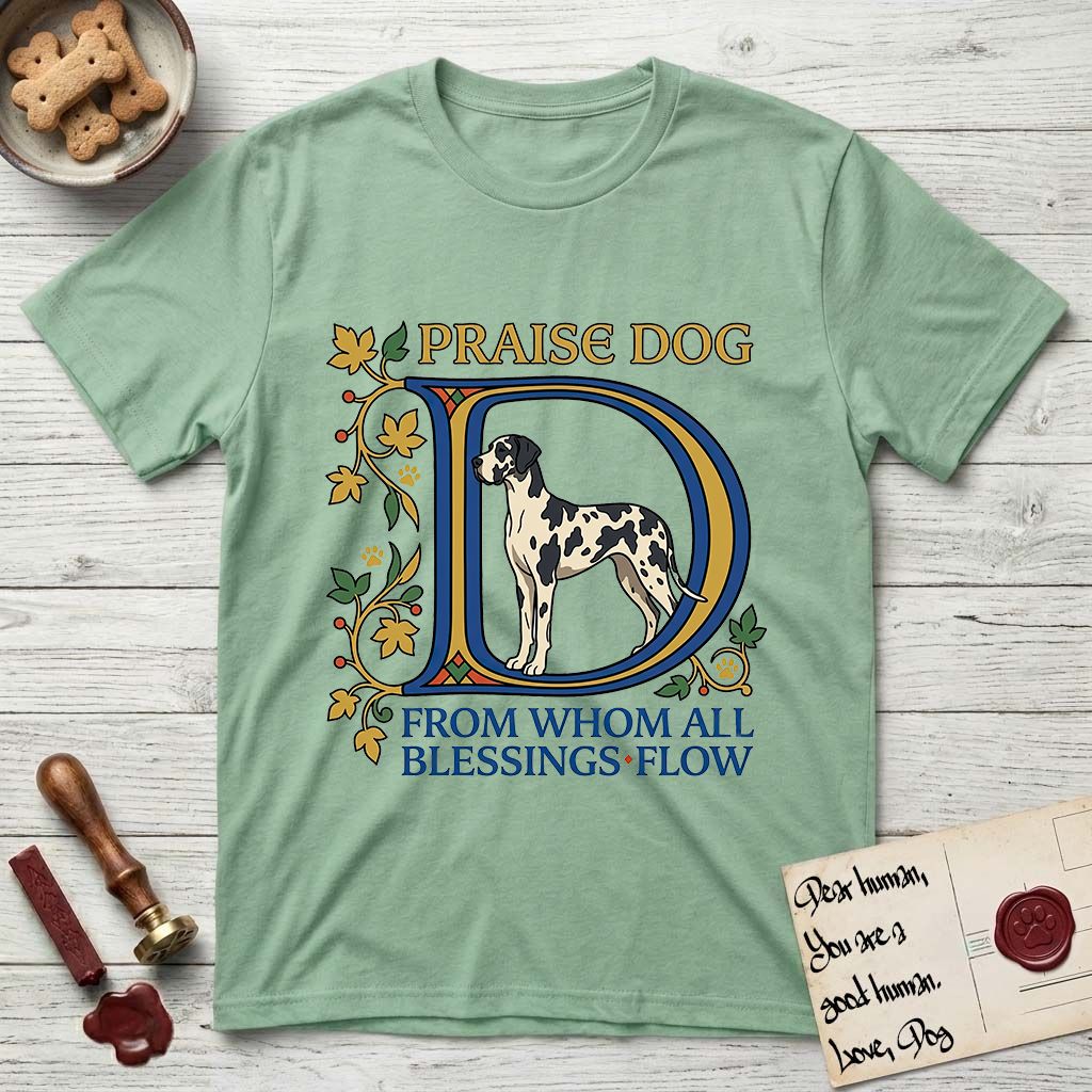 Praise Dog From Whom All Blessings Flow Great Dane T-Shirt flat lay in Mint Green, featuring an illuminated manuscript capital D in blue and gold with a harlequin Great Dane standing inside the letter and the words Praise Dog From Whom All Blessings Flow.