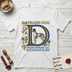 Praise Dog From Whom All Blessings Flow Great Dane T-Shirt flat lay in White, featuring an illuminated manuscript capital D in blue and gold with a harlequin Great Dane standing inside the letter and the words Praise Dog From Whom All Blessings Flow.
