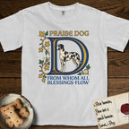 Praise Dog From Whom All Blessings Flow Great Dane T-Shirt flat lay in White, featuring an illuminated manuscript capital D in blue and gold with a harlequin Great Dane standing inside the letter and the words Praise Dog From Whom All Blessings Flow.