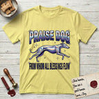 Praise Dog From Whom All Blessings Flow Greyhound T-Shirt flat lay in Cornsilk, featuring a retro chrome airbrush design with a Greyhound running at full stretch among sparkle stars and the words Praise Dog From Whom All Blessings Flow in chrome sunset lettering.