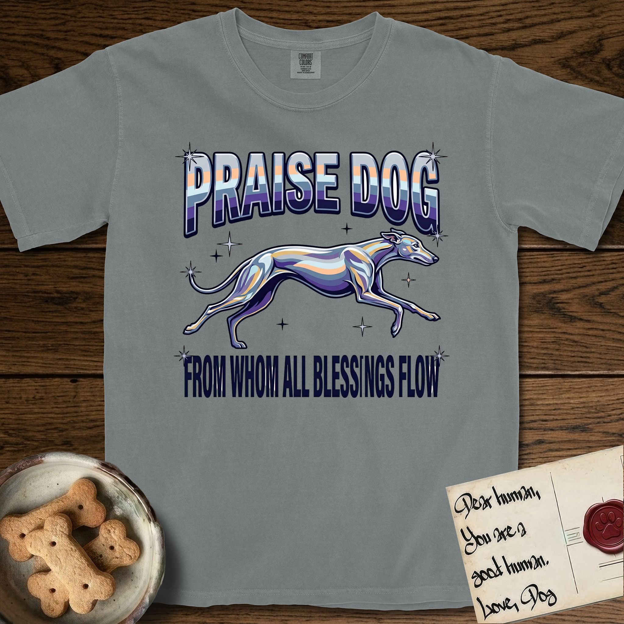 Praise Dog From Whom All Blessings Flow Greyhound T-Shirt flat lay in Granite, featuring a retro chrome airbrush design with a Greyhound running at full stretch among sparkle stars and the words Praise Dog From Whom All Blessings Flow in chrome sunset lettering.