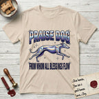 Praise Dog From Whom All Blessings Flow Greyhound T-Shirt flat lay in Sand, featuring a retro chrome airbrush design with a Greyhound running at full stretch among sparkle stars and the words Praise Dog From Whom All Blessings Flow in chrome sunset lettering.