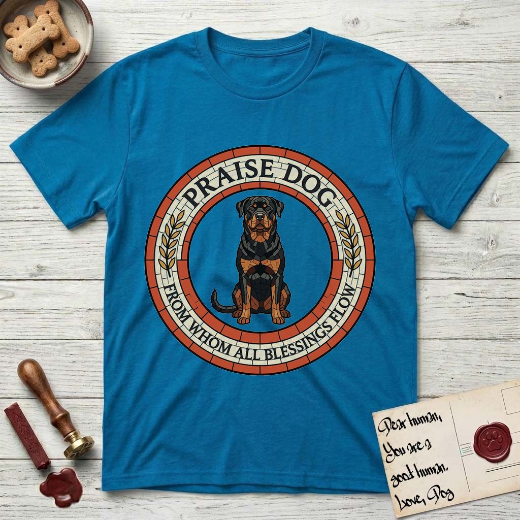 Praise Dog From Whom All Blessings Flow Rottweiler T-Shirt flat lay in Sapphire, featuring a Roman mosaic ring medallion of a seated Rottweiler with natural ears and a full undocked tail, built from terracotta and mahogany tiles and flanked by laurel branches, with "Praise Dog From Whom All Blessings Flow" lettering.