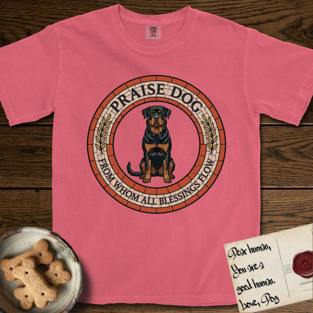 Praise Dog From Whom All Blessings Flow Rottweiler T-Shirt flat lay in Watermelon, featuring a Roman mosaic ring medallion of a seated Rottweiler with natural ears and a full undocked tail, built from terracotta and mahogany tiles and flanked by laurel branches, with "Praise Dog From Whom All Blessings Flow" lettering.